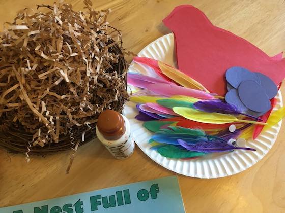 shredded paper, construction paper bird and eggs, craft feathers, googly eyes