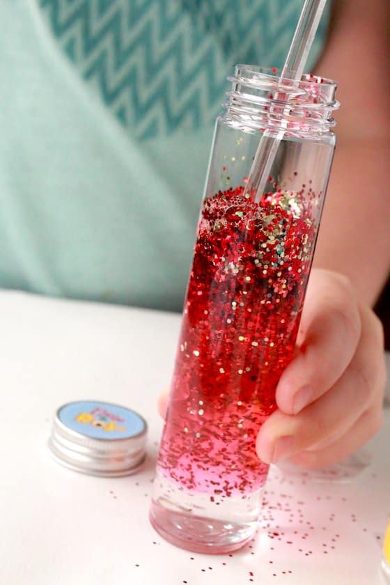 stirring glitter into bottle of water