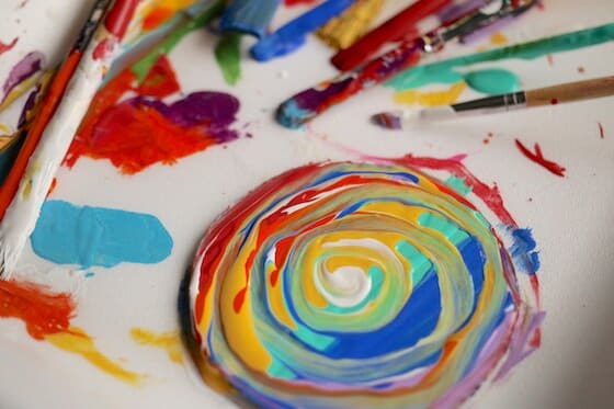 Rainbow swirls of paint on cardboard circle