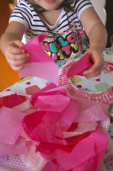 Toddler making tissue paper wreath