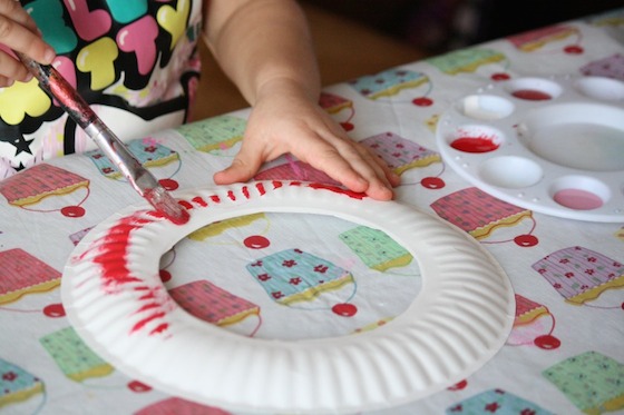 Toddler painting paper plate red