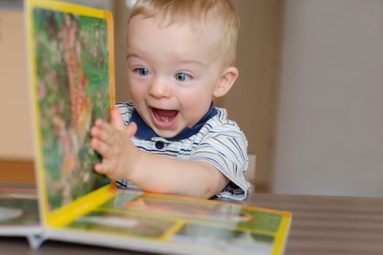 Toddler boy turning pages of book