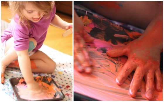 Toddler with hands in paint tray