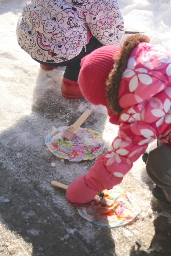 toddlers painting with snow on coffee filters