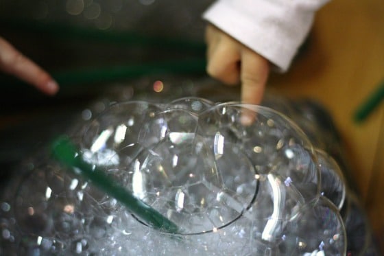 toddlers blowing bubble towers with a straw