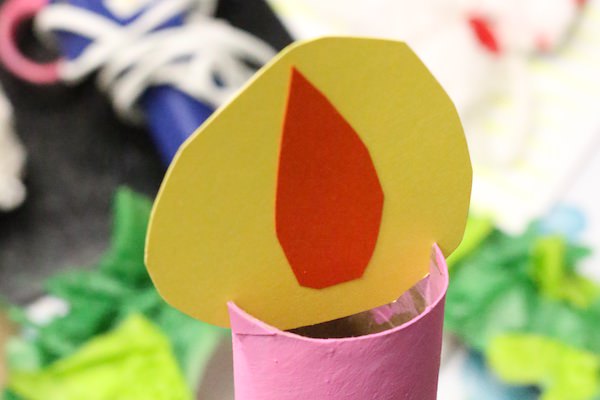 paper flame inserted into slits in top of pink cardboard roll