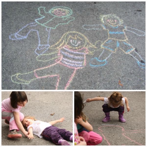 Kids tracing their bodies with sidewalk chalk 