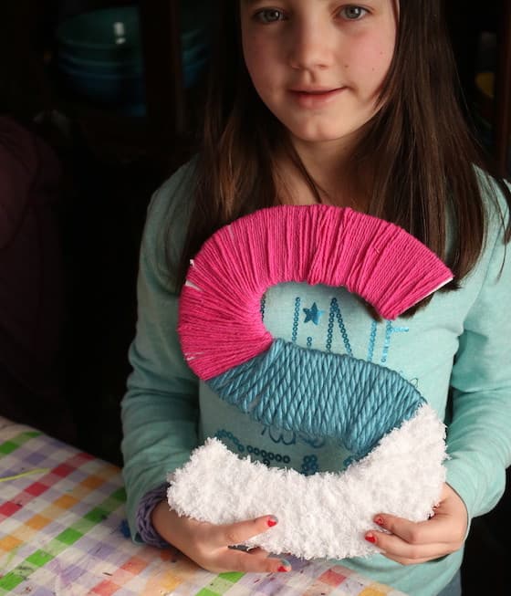 Tween holding yarn wrapped letter S