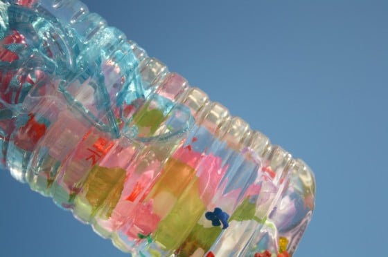 clear discovery bottle for preschoolers with water, beads and ribbons in side