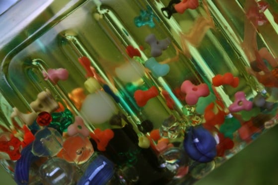 clear plastic bottle filled with coloured water and small trinkets