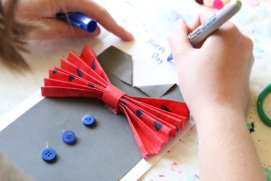 Kid writing message on Father's Day Card