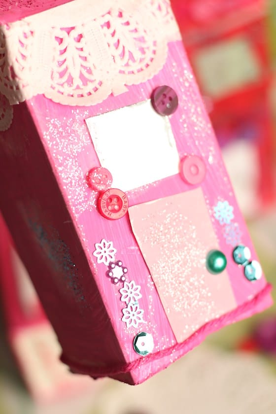 Yarn, buttons and sequins on pink milk carton house