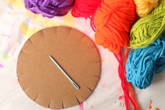 Yarn, cardboard circle, sewing needle